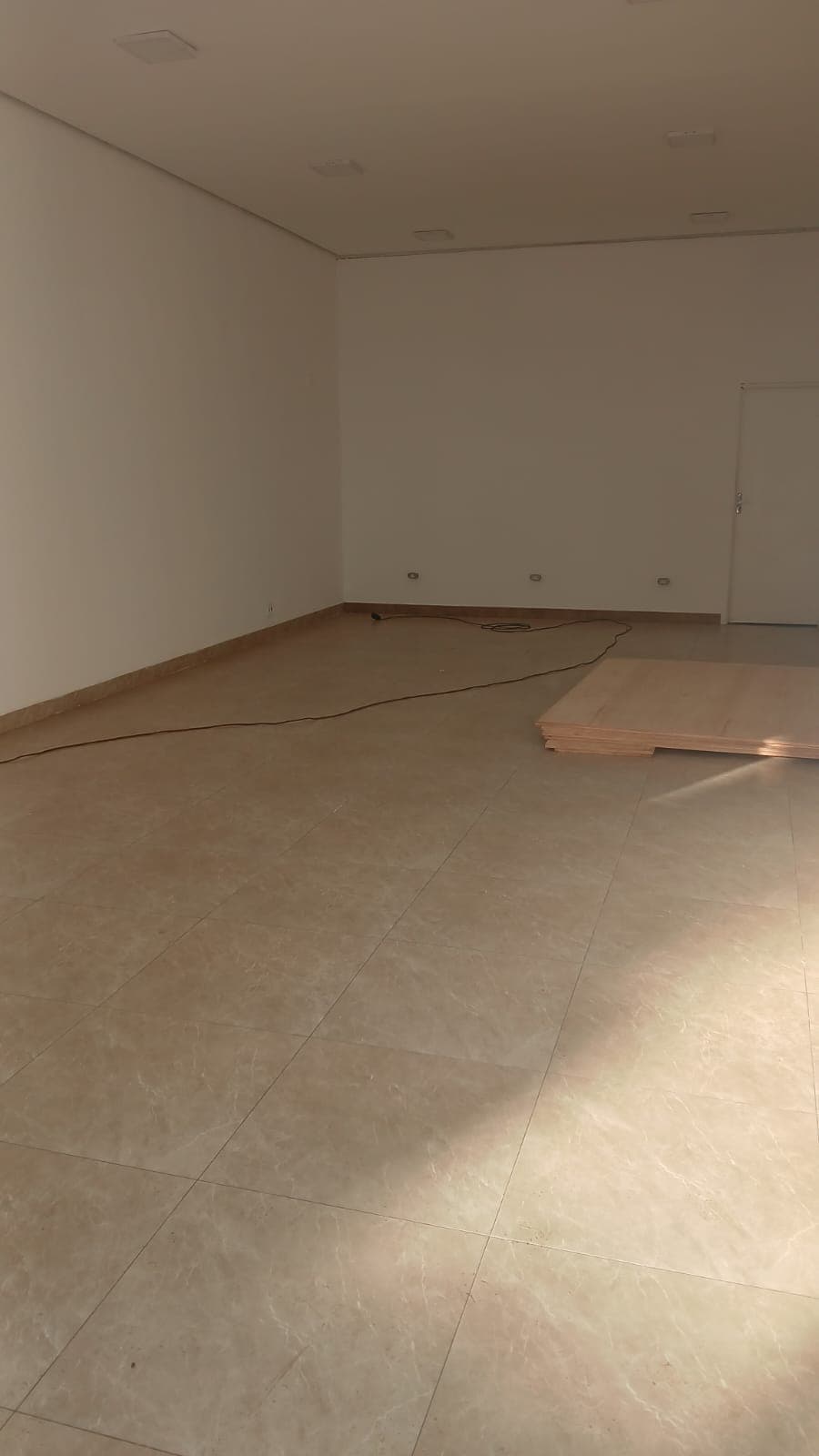 Salão principal do imóvel da Rua 7 de Setembro, 665, amplo, com piso porcelanato claro e iluminação embutida
